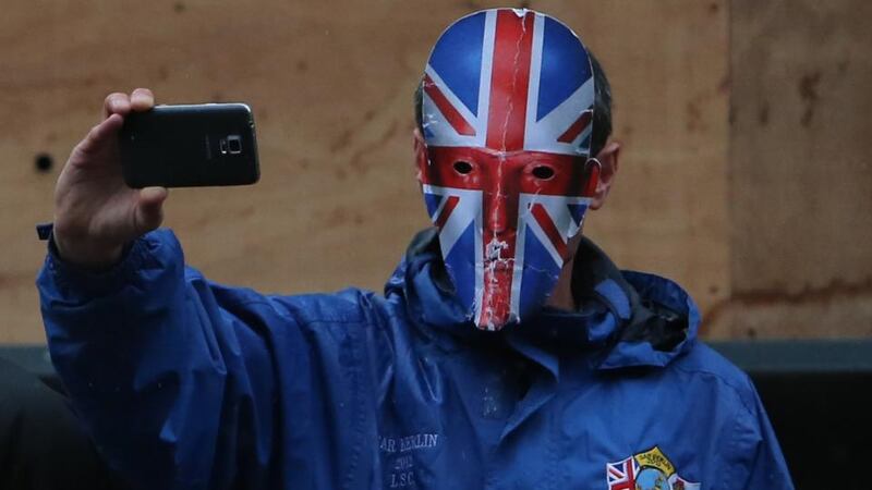 A loyalist protester takes photographs at the march in Belfast today.  Photograph: Niall Carson/PA Wire