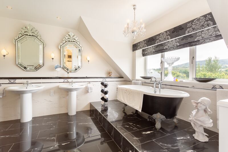 The main bedroom has a stunning en suite bigger than any family bathroom, with his-and-hers suite, raised bath and separate shower