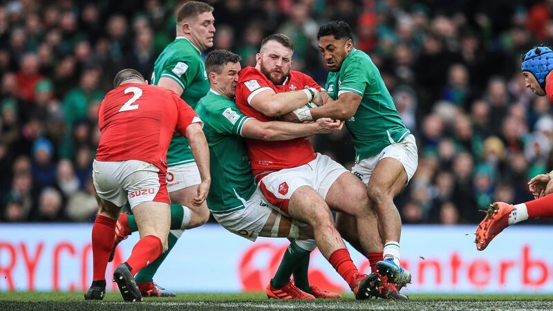 Sexton and Bundee Aki tackle Dillon Lewis. Photo: Gary Carr/Inpho