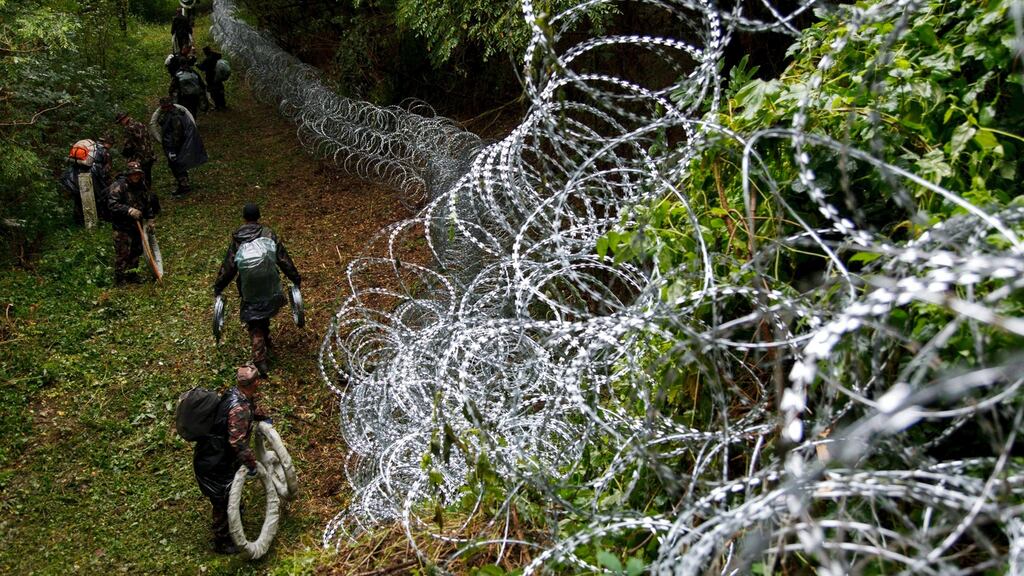 Hungarian soldiers build a temporary razor-wire fence at the border between Hungary and Croatia. Photograph: Gyorgy Varga/EPA