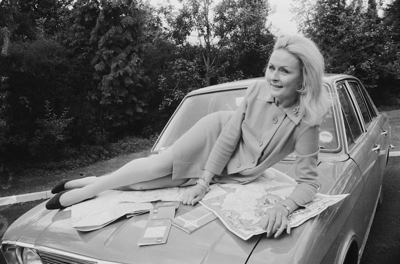 Rally driver Rosemary Smith lies on the hood of a car with road maps, in 1968. Photograph: Daily Express/Getty Images
