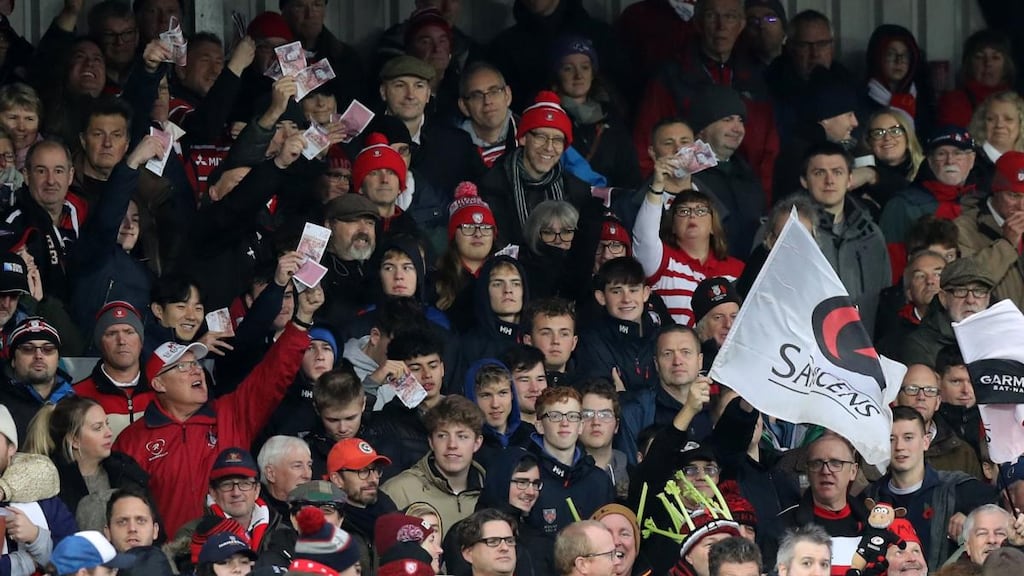Gloucester supporters wave fake money during the Gallagher Premiership Rugby match against Saracens at Kingsholm. Photograph: David Rogers/Getty Images