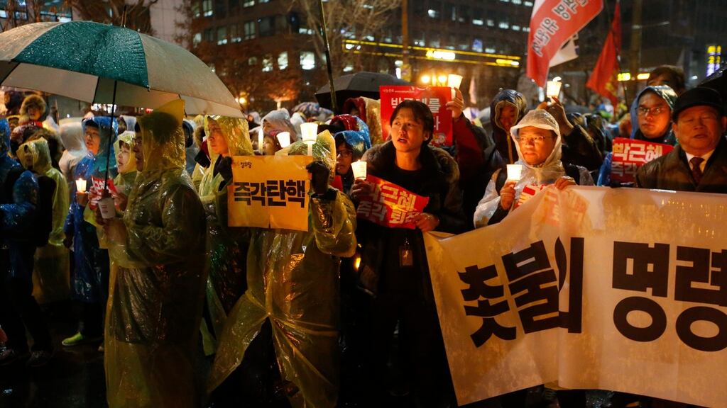 South Koreans march toward national assembly carrying placards saying ‘Park Geun-Hye Out’. Photograph: Jon Heon-kyun/EPA