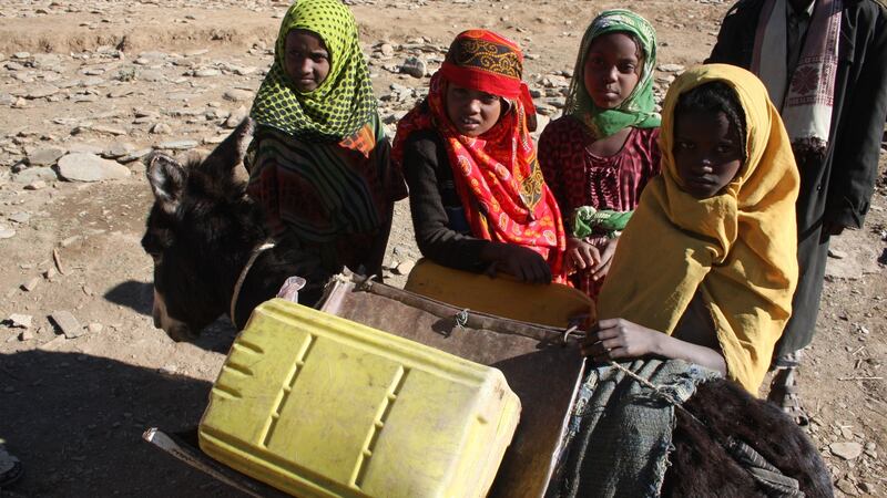 Girls collect water at a donor-funded well to take home by donkey. Photograph: James Jeffrey