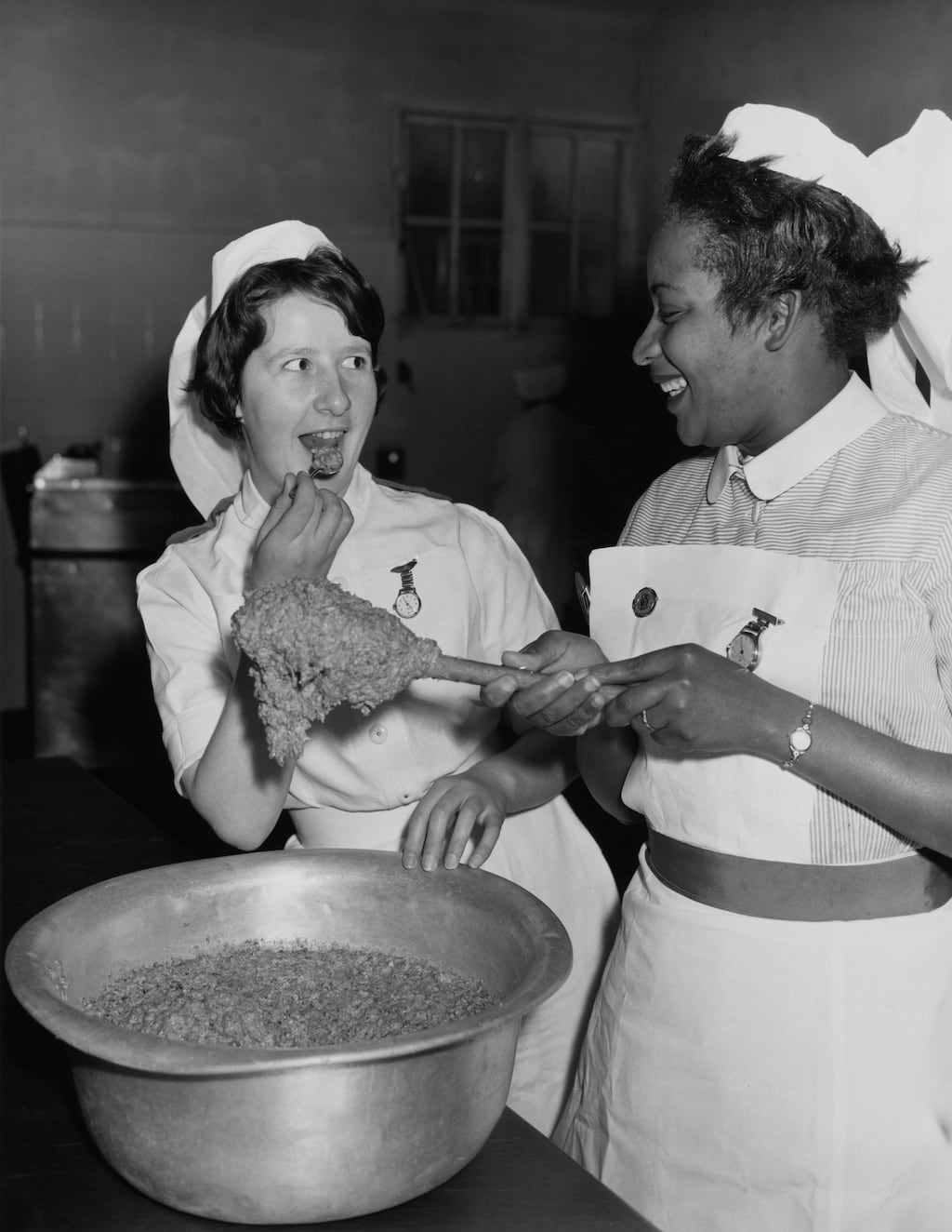 Irish nurse Theresa McHugh tastes the Christmas pudding mixture as Barbadian nurse Julien laughs at Wembley Hospital in London in 1960. Photograph: Fred Morley/Fox Photos/Hulton Archive/Getty Images
