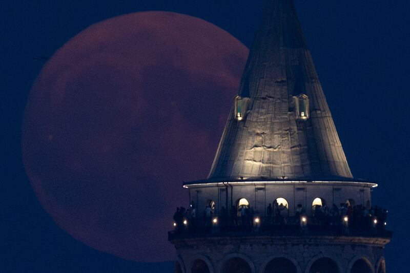 Tourists visit Istanbul's famous Galata Tower as a rare super blue moon rises behind. Photograph: Chris McGrath/Getty Images
