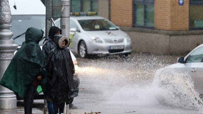 People wait at a pedestrain crossing during a downpour in Dublin. Photo: Laura Hutton/Collins Photo Agency