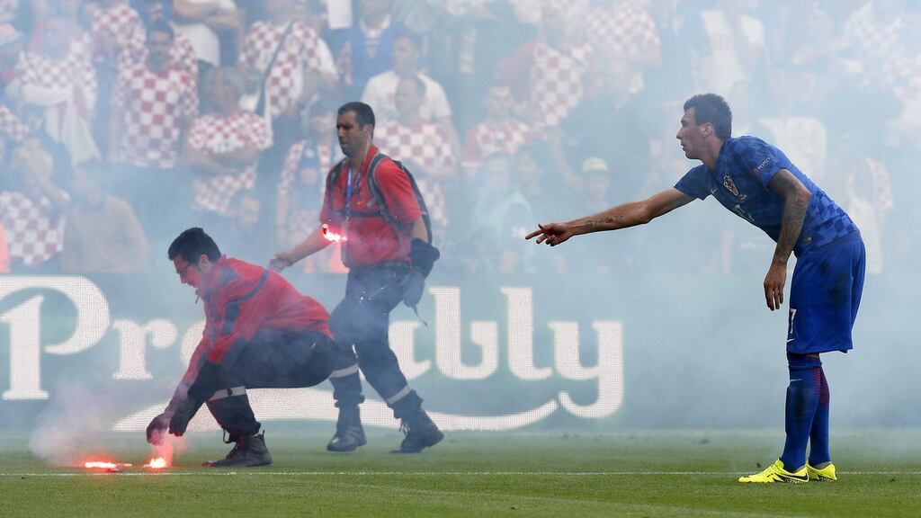 A steward removes flares from the pitch during the Euro 2016 Group D match between Czech Republic and Croatia in St Etienne. Photo: Sergey Dolzhenko/Getty Images