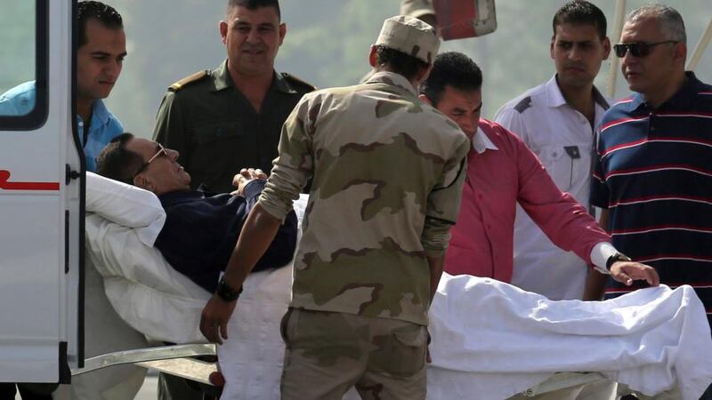 Former Egyptian president Hosni Mubarak lies on a stretcher as he is transported from a helicopter into an ambulance on his way to his trial in Cairo today. Photograph: Reuters