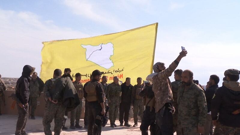 A screen grab released by the Kurdish Ronahi TV on Saturday  shows the US-backed Syrian Democratic Forces (SDF) raising their flag atop a building in the Islamic State group’s last bastion in the eastern Syrian village of Baghouz after defeating the jihadist group. Photograph: Ronahi TV/AFP/Getty Images.