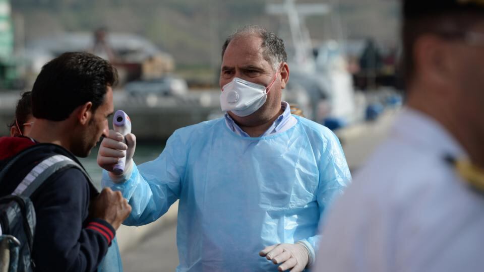 Health check: Officials taking migrants’ temperatures, as they come ashore at Porto Empedocle in Sicily, to test for communicable diseases. Photograph: Frank Miller