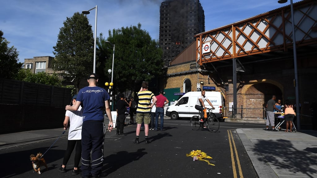 People watch from Latimer Road Station at the smoking 24-storey Grenfell Tower block in Latimer Road, West London. Photograph: Leon Neal/Getty Images