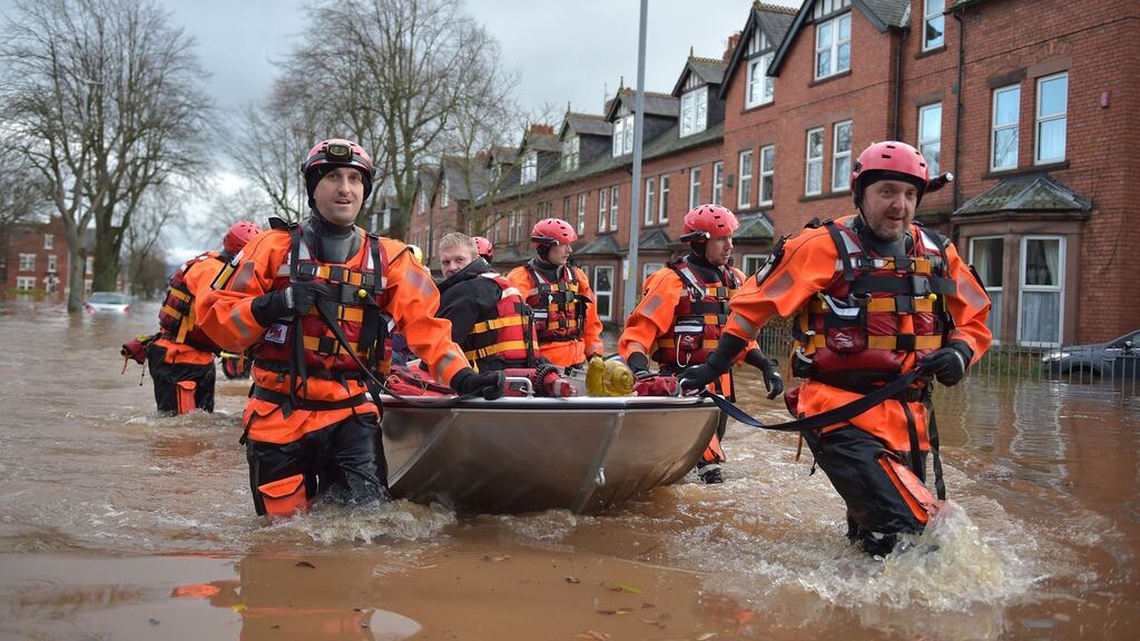 A rescue team helps to evacuate people from their homes after Storm Desmond caused flooding in Carlisle, England. Photograph: Jeff J Mitchell/Getty Images.
