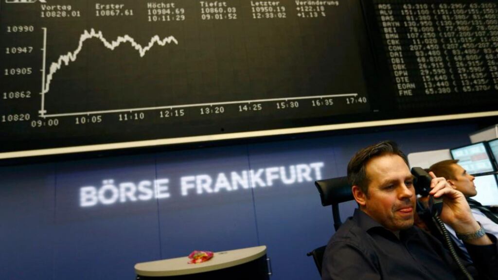 German bourse trader Matthias Praeger looks up to check his monitors as he sits in front of the German share price index DAX board at the stock exchange in Frankfurt. Photograph: Kai Pfaffenbach/Reuters