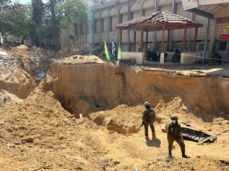 Israeli soldiers stand in a hole used to gain access to the tunnel underneath the hospital. Photograph: Patrick Kingsley/New York Times