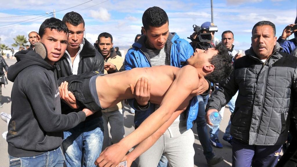 A young Tunisian who tried to commit suicide is carried   to get medical help in  Kasserine: If Tunisia was hailed as the success story of the Arab Spring , it has also become an example of the dangers in failing to tackle   the frustrations of its youth. Photograph: Mohamed Khalil/AFP/Getty Images