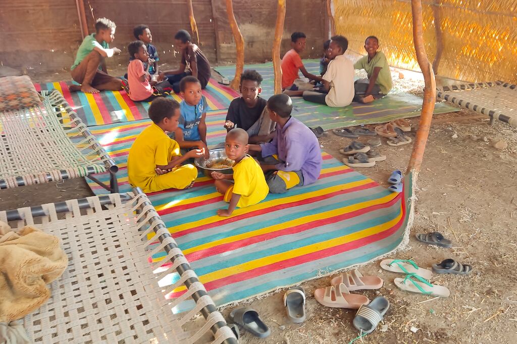 Children sharing a bowl of food earlier this week as Sudanese families host internally displaced people coming from the central Sudanese state of Gezira to the eastern Sudanese city of Gedaref. Photograph: Ebrahim Hamid/AFP via Getty Images