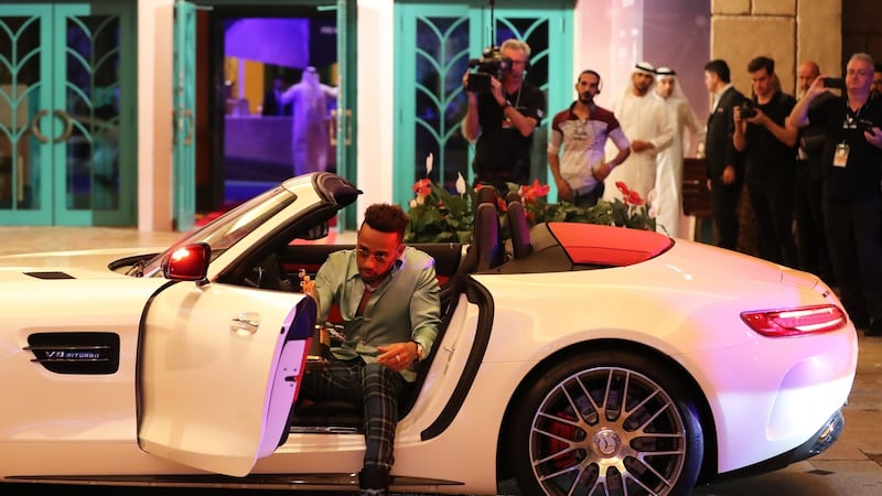 British Formula One driver Lewis Hamilton arrives with the “Global Teacher Prize” trophy for the awards ceremony in Dubai. Photograph: Karim Sahib/AFP/Getty Images