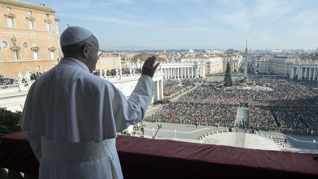 Pope Francis standing on a balcony of St Peter’s basilica during the traditional “Urbi et Orbi” Christmas message to the city and the world. Photograph: Osservatore Romano/AFP/Getty Images