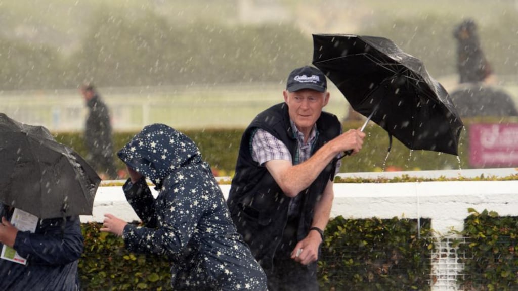 Punters at the Galway Races attempt to take shelter from the rain. Photograph: Cyril Byrne