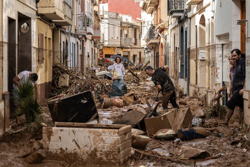 Residents clean up a mud-and-debris-covered street after flooding hit large parts of the country on October 31st in the Paiporta municipality of Valencia, Spain. Photograph: David Ramos/Getty Images