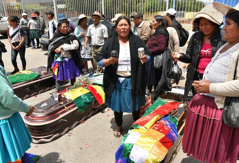 A group of women perform a ceremony around the coffins of those who died in clashes with the police. Photograph: Jorge Abrego/EPA