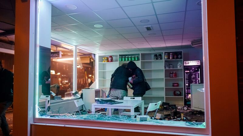 People loot a shop during clashes between police and a large group of young people in Rotterdam on Monday. Photograph: Marco de Swart/ANP/AFP via Getty Images