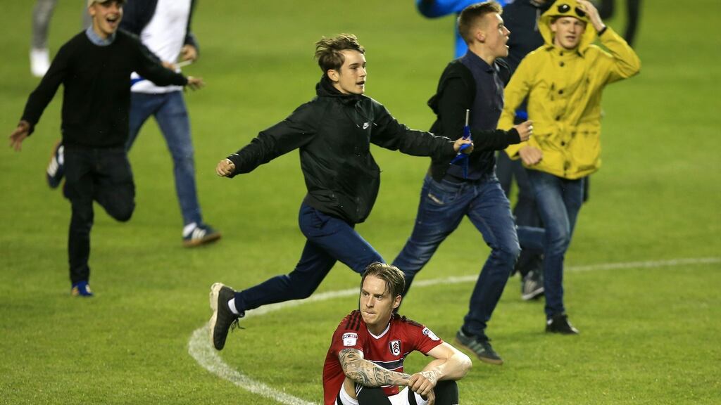 Reading fans run past Stefan Johansen of Fulham after their side reached the Championship playoff final with a 1-0 win. Photo: Ben Hoskins/Getty Images