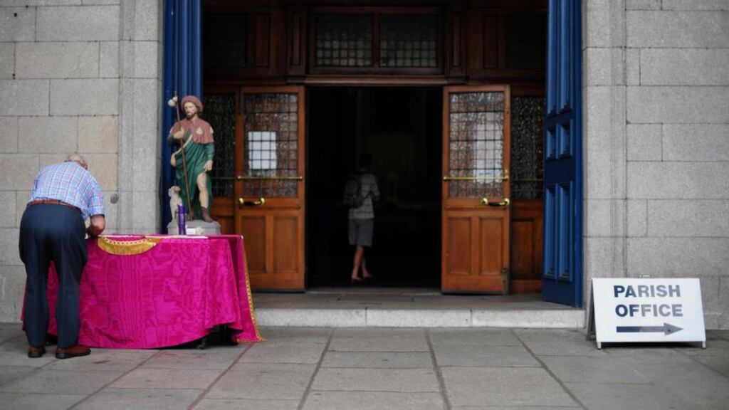 A member of the public signs a book of condolonces today outside St Andrew’s Parish Church in Westland Row, Dublin, for the victims of the Spanish train crash. Photograph: Aidan Crawley