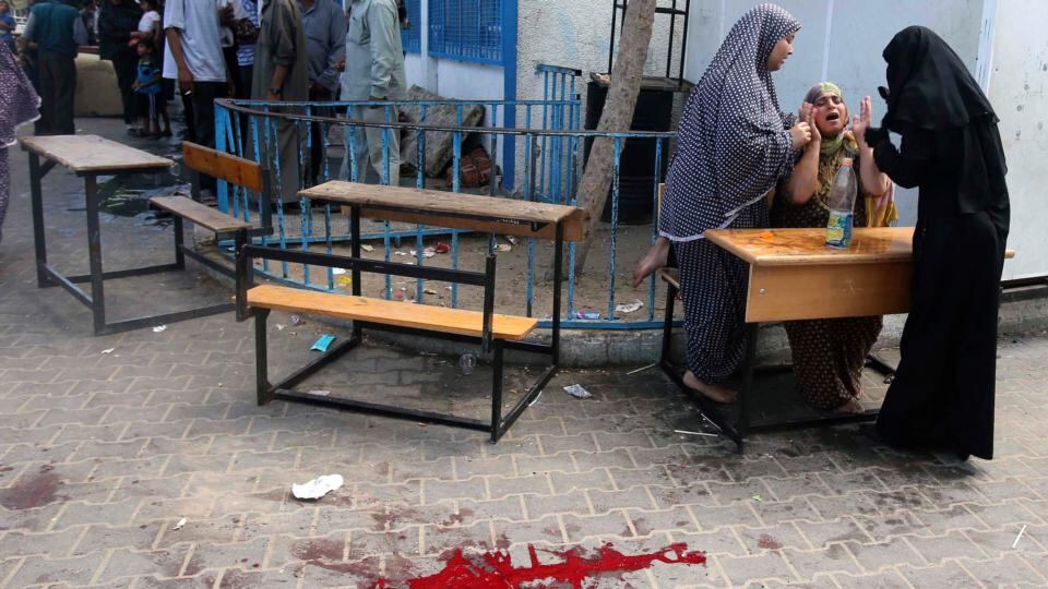 A Palestinian woman reacts as a pool of blood from wounded and dead people is seen on the ground following what witnesses said was an Israeli air strike at a United Nations-run school, where displaced Palestinians take refuge, in Rafah . Photograph: Ibraheem Abu Mustafa/Reuters