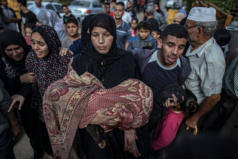 A woman carries the body of her child, killed in an air strike on a house in the Khan Younis refugee camp in the southern Gaza Strip, on Wednesday. Photograph: Haitham Imad/EPA