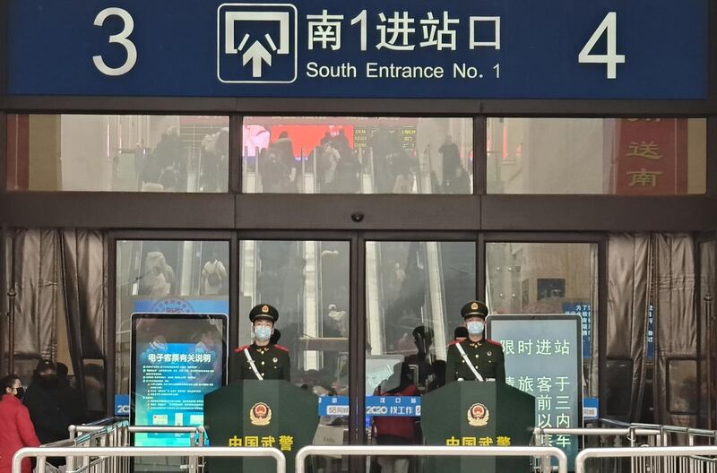 Guards wearing face masks stand at Hankou railway station in Wuhan, China on Wednesday. Photograph: Xiaolu Chu/Getty
