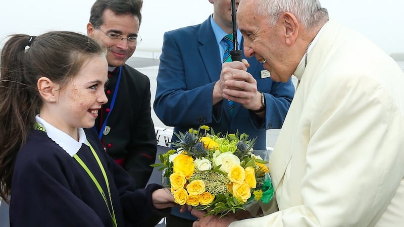 Pope Francis is presented with flowers by Saoirse McCarthy (11) from St Patrick’s National School, Cloonlyon, Co Mayo, as he arrives at Knock Airport. Photograph: Maxwell Photography
