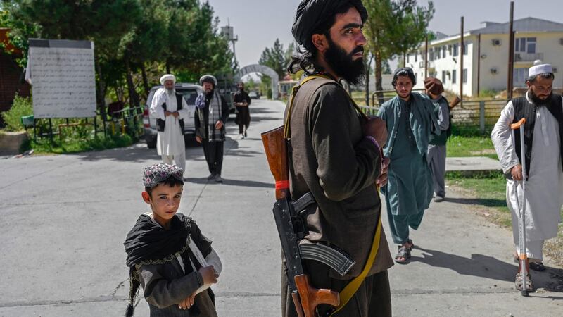 An Afghan boy and a member of the Taliban in front of the Pul-e-Charkhi prison in Kabul. Photograph: Bulent Kilic/AFP via Getty Images