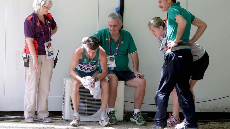 Rob Heffernan is consoled by Irish athletic team manager Patsy McGonagle and team members after finishing fourth in the Men’s 50km Race Walk at the London Olympics in 2012. Photograph: Morgan Treacy/INPHO
