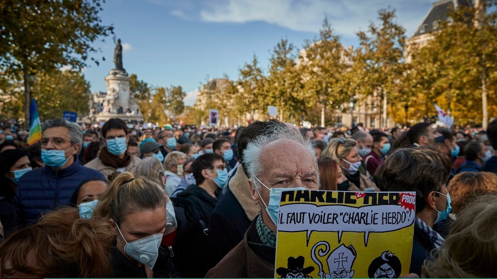 A protester holds a copy of the satirical newspaper Charlie Hebdo during an anti-terrorism vigil on Sunday at Place de La Republique in Paris for the murdered schoolteacher Samuel Paty. Photograph: Kiran Ridley/Getty Images