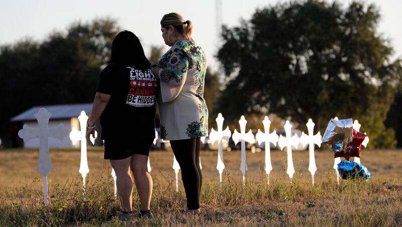 Sonia Yanez and Laura Torres visit a line of crosses before a vigil for the victims of Sunday’s First Baptist Church shooting, in Sutherland Springs, Texas. Photograph: David J Phillip/AP Photo