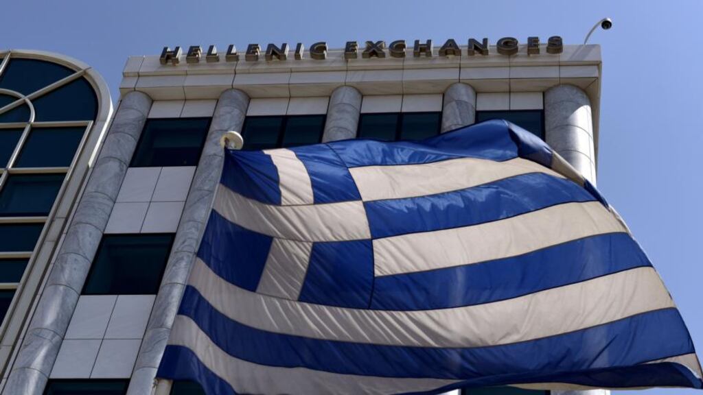 A Greek flag is pictured outside the Athens Stock Exchange in Athens Photograph:  Aris Messinis/AFP/Getty Images
