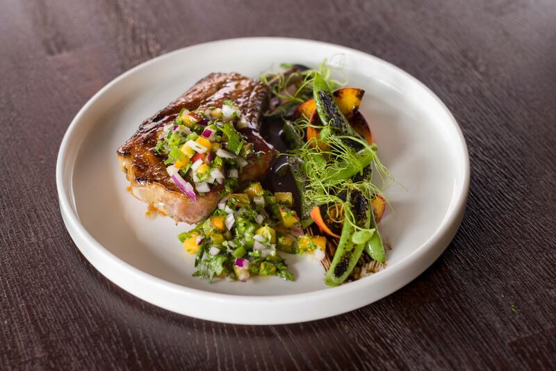 Char-grilled Andarl farm pork chop, peach, jalapeno, sugar snap and baby potatoes from the a la carte menu at Loretta’s.
Photograph: John Ohle