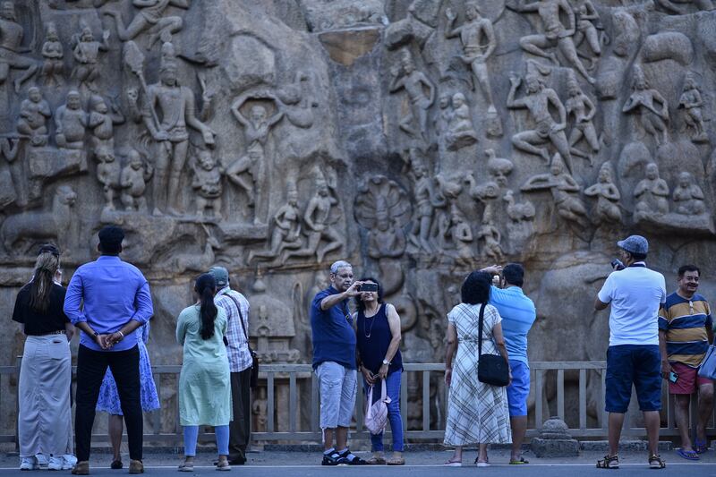 Visitors near the Arjuna's Penance monument on World Tourism Day, at the coastal town of Mahabalipuram, situated about 50km from Chennai, India. Photograph: Idrees Mohammed/EPA