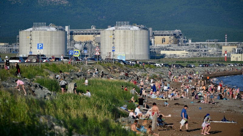 People sunbathe on a beach in July 2021 by the Aniva Bay, near a Sakhalin Energy Company oil and gas facility on the southern shore of Sakhalin Island. Photograph: Yuri Smityuk/Tass via Getty Images