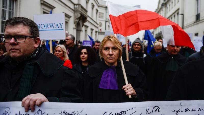 A judge holds a Polish flag during the Thousand Scarlet Robes March. Photograph: Getty