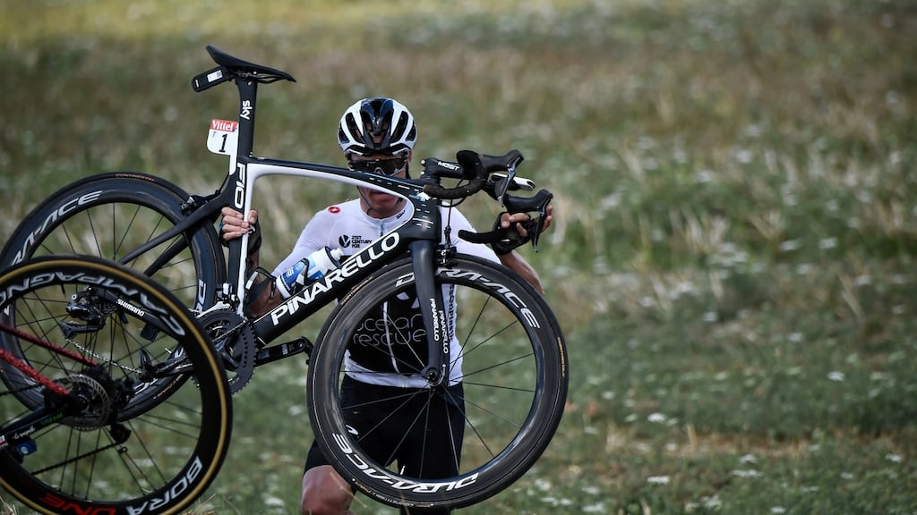 Chris Froome carries his bicycle after falling into a ditch during the first stage. Photograph: Jeff Pachoud/Reuters