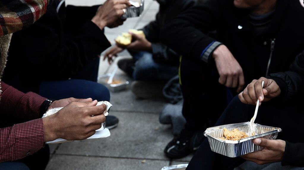 Afghan migrants receive food from volunteers in a square outside Victoria metro station in central Athens. Photograph: Simela Pantzartzi/EPA