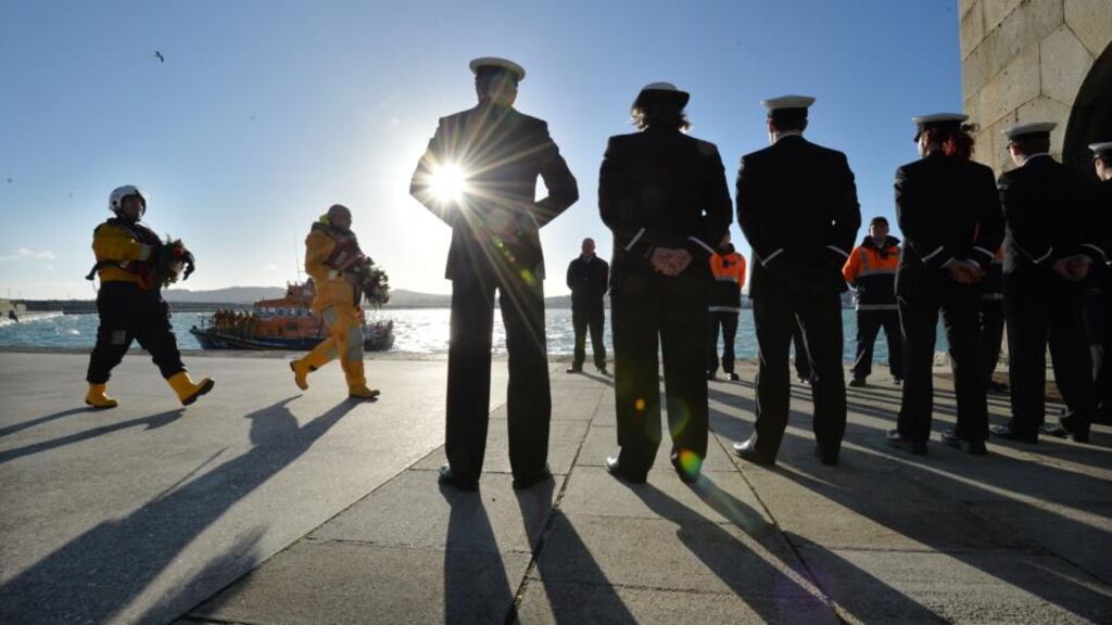 Members of the Coast Guard and the Civil Defence form a guard of honour as RNLI Dun Laoghaire crew members Daragh Brady and Eamon O’Leary conduct a ceremony on the East Pier to remember the 15 volunteers that died on service in 1895 on Christmas Eve . Photograph: Alan Betson / The Irish Times