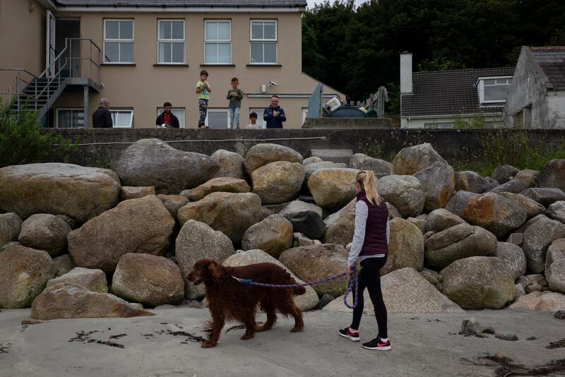 A local woman with her dog chatting with Ukrainians and their host on Arranmore Island. Across Donegal, much support for the refugees has fallen to a patchwork of local agencies, charities and volunteers. Photograph: Paulo Nunes dos Santos/New York Times