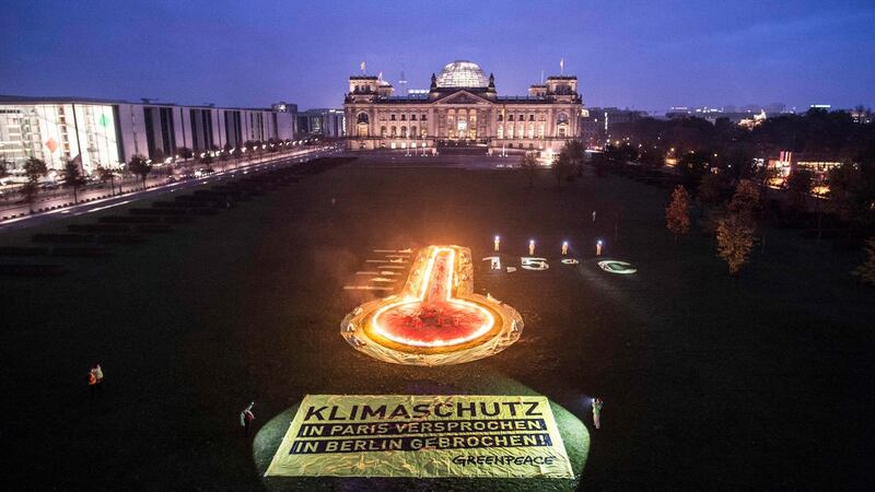 A banner reading “Climate protection – promised in Paris – promise broken in Berlin” during a protest by Greenpeace on the lawn in front of the Reichstag building in Berlin earlier this month. Photograph: Paul Zinken/EPA
