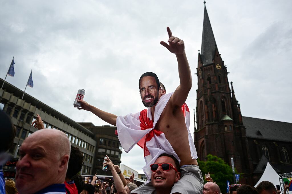 An England fan wearing a mask of Gareth Southgate cheers during a gathering in Gelsenkirchen before England's match against Slovakia on Sunday. Photograph: Ina Fassbender/AFP via Getty Images