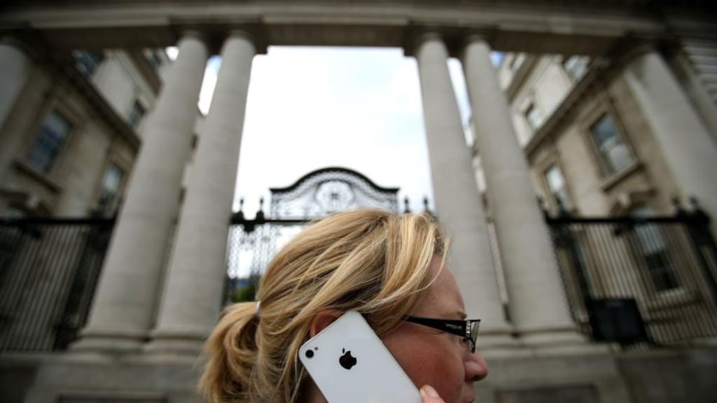 A woman on her Apple iPhone outside Government Buildings in Dublin yesterday. Photograph: Julien Behal/PA Wire