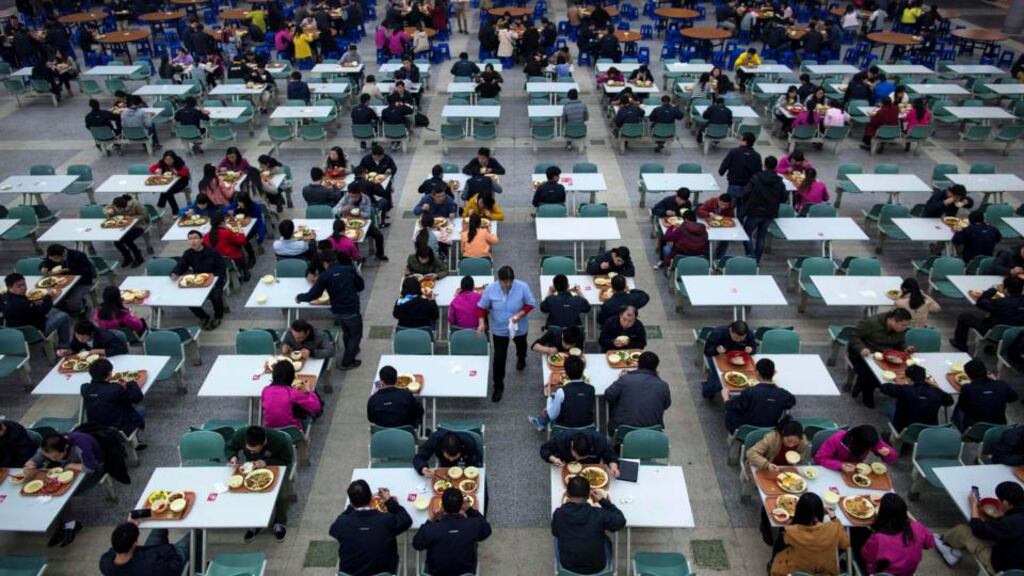 Workers eat their lunch at a restaurant inside a Foxconn factory in the township of Longhua in Shenzhen, Guangdong province. The the group currently employs about 1.3 million people during peak production times, but is expected to reduce its workforce. (Photograph: Tyrone Siu/Reuters)